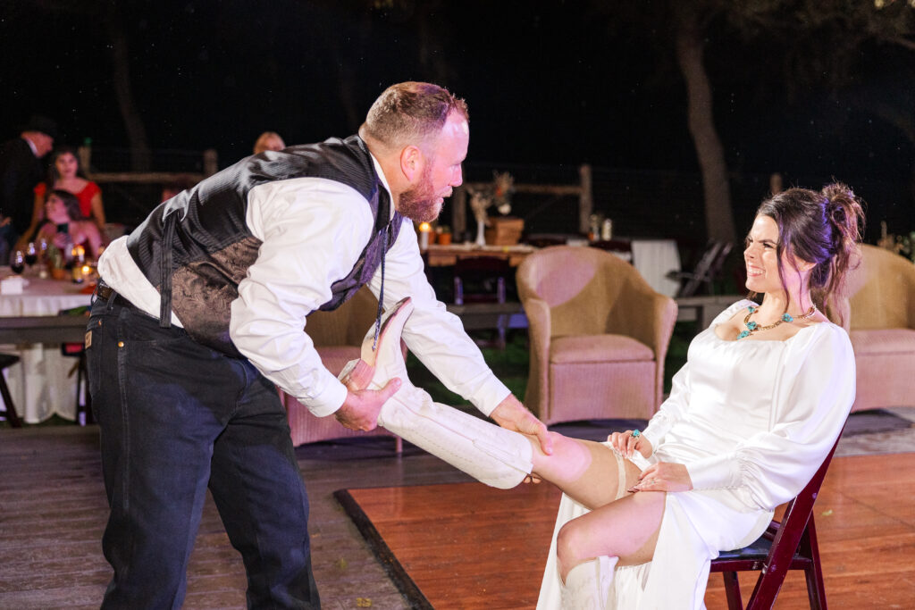 San Antonio groom prepares to take the bride's garter off during the San Antonio wedding reception -wedding night tips