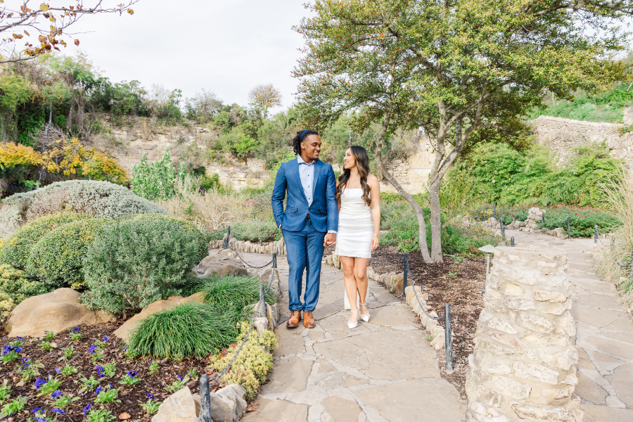 While taking San Antonio engagement photos, the bride and groom to be started strolling through a beautiful garden along a stone path.