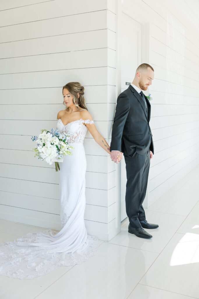 Dallas bride and groom hold hands for a first touch before their wedding ceremony at The Gardenia venue