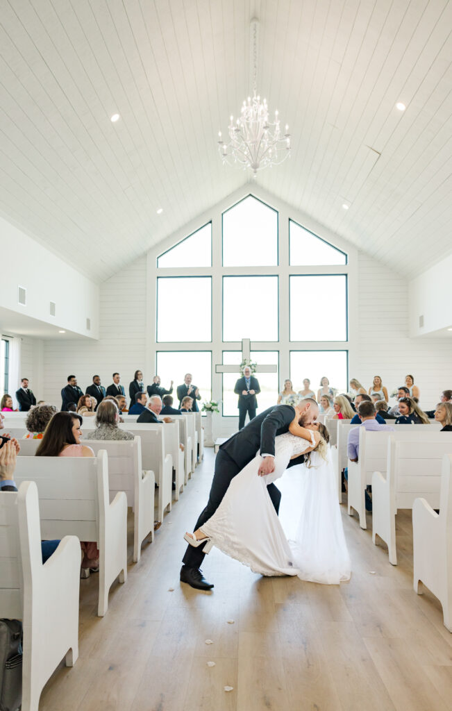 Groom dips bride at their wedding ceremony at The Gardenia venue