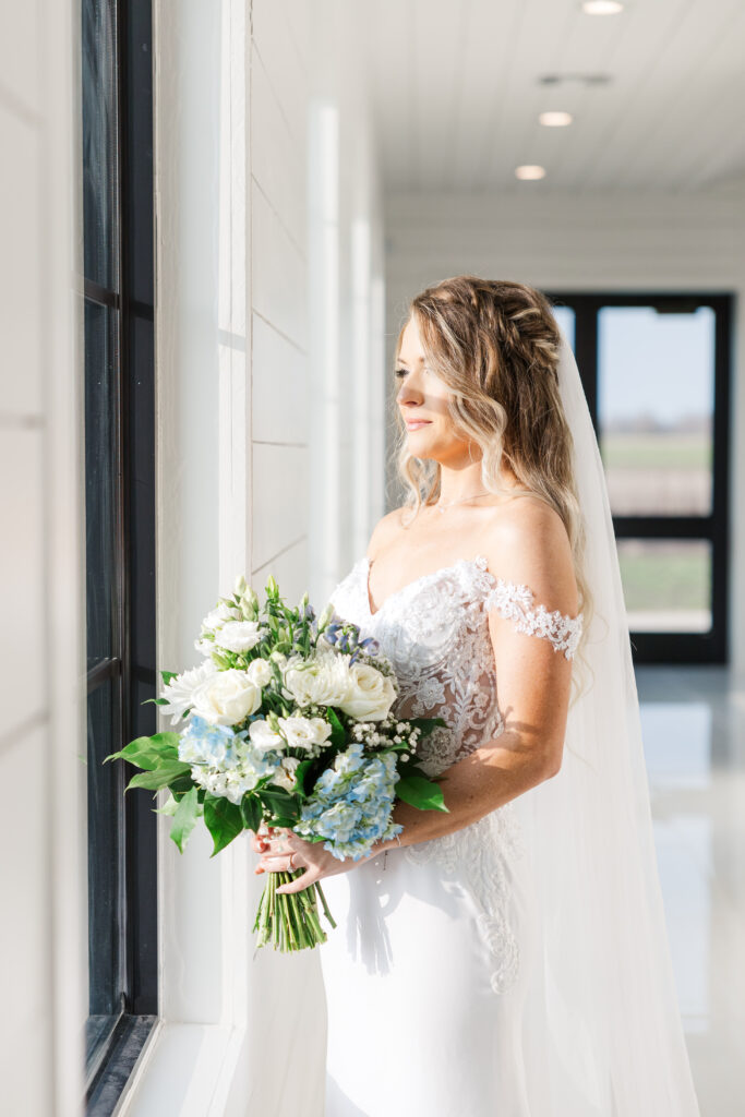 Dallas bride looks out at the window of the getting ready room at The Gardenia Venue